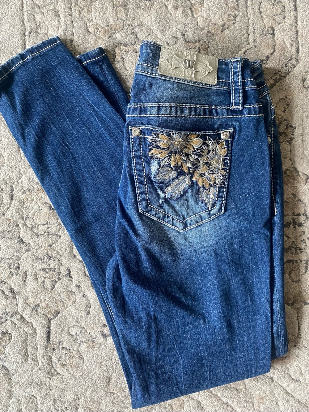 Miss Me Dark Blue Mid Rise Skinny Jeans with Gold Floral Embroidered Pocket.